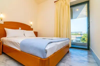 a bedroom with a bed and a large window at Orestis Hotel Sea View Apartments in Stalos