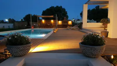 a wooden deck with a swimming pool and a house at Sea Queen Villa in Kato Daratso