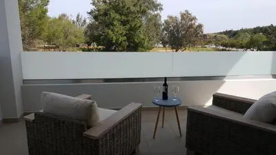 a balcony with two chairs and a table and a window at Sea Queen Villa in Kato Daratso