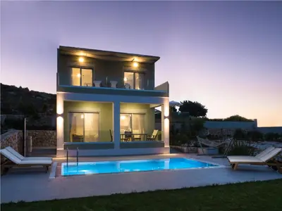 a villa with a swimming pool in front of a house at Κatakis Villas in Agios Onoufrios