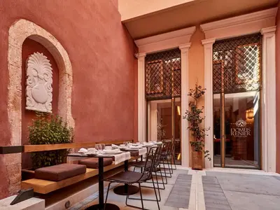 a restaurant with a table and chairs on a patio at Domus Renier Boutique Hotel in Chania Town