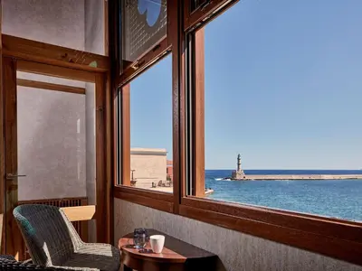 a room with a window with a view of the ocean at Domus Renier Boutique Hotel in Chania Town