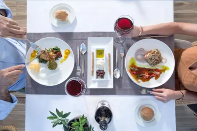 a group of people sitting around a table with plates of food at Thalassa Beach Resort & Spa (Adults Only) in Agia Marina Nea Kydonias