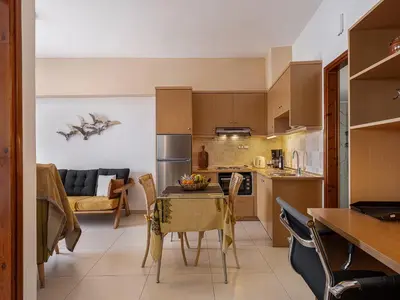 a kitchen and living room with a table and chairs at Stam's Paradise in Chania Town