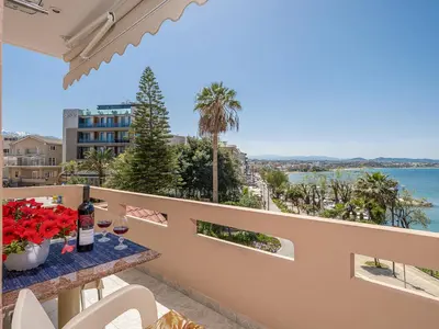 a balcony with a table with flowers and a view of the water at Stam's Paradise in Chania Town