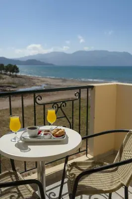 a table with a plate of food and drinks on a balcony at Mesogios Beach in Kissamos