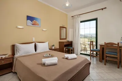 a bedroom with a bed with a table and a desk at Mesogios Beach in Kissamos
