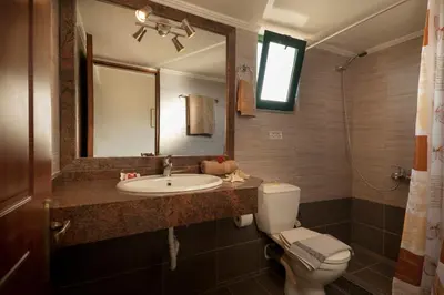 a bathroom with a sink and a toilet and a mirror at Mesogios Beach in Kissamos