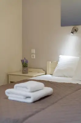 a bed with two white towels on top of it at Geana Apartments in Chania Town
