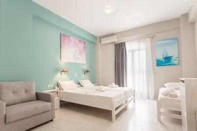 a living room with a couch and a chair at Protopapas Rooms in Loutro