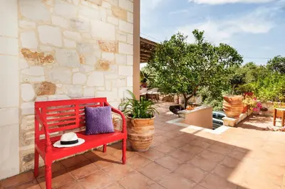 a red bench with a hat sitting on a patio at My Villa Dafni in Stalos