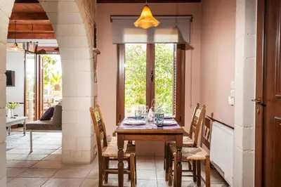 a dining room with a wooden table and chairs at My Villa Dafni in Stalos