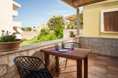 a wooden table and two chairs on a balcony at My Villa Dafni in Stalos