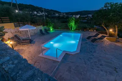 a swimming pool in a backyard at night at Dekem Residence in Gavalochori