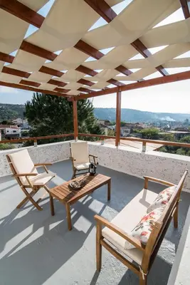 a patio with two chairs and a table on a roof at Dekem Residence in Gavalochori