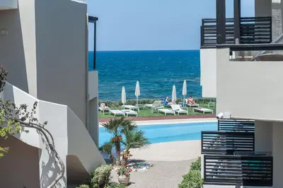 a swimming pool with the ocean in the background at Corinna Mare in Kalamaki Chanion