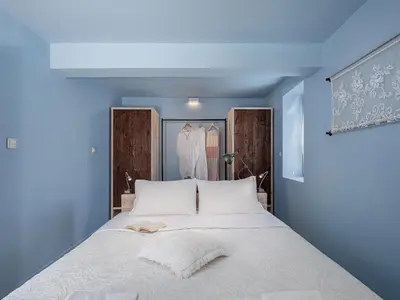 a bedroom with a bed with blue walls at Geraniotis Villa in Gerani Chanion