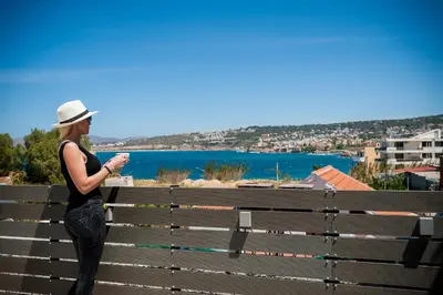 a woman standing on a bench looking at her cell phone at Casa di Gouto in Chania Town
