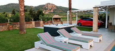 a patio with two chairs and a grill and a car at Villa Alexandros in Kissamos