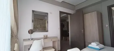 a bedroom with a bed and a desk and a mirror at Villa Alexandros in Kissamos