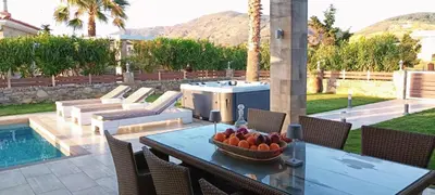 a patio with a table with a bowl of fruit on it at Villa Alexandros in Kissamos