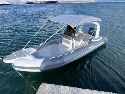 a white boat with a canopy on the water at Hostel Stylianos Kissamos in Kissamos