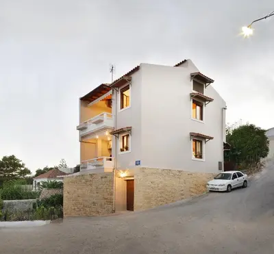 a white house with a car parked in front of it at Melli House in Melissouryíon