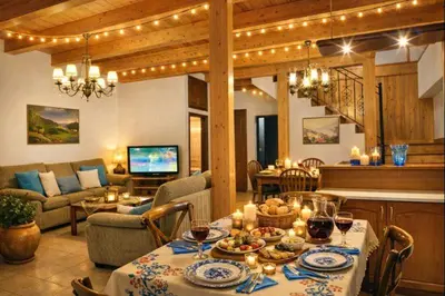 a dining room and living room with a table with candles at Melli House in Melissouryíon