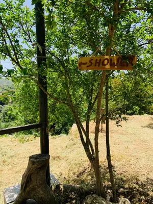 a wooden sign on a pole next to a tree at Temenia House in Teménia