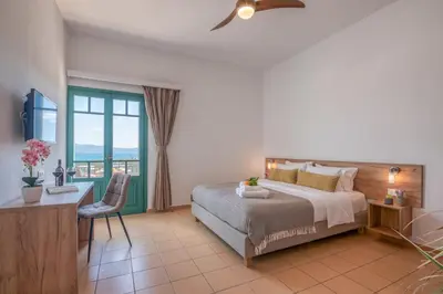 a bedroom with a bed and a desk and a window at Kaliviani Traditional Hotel in Kissamos
