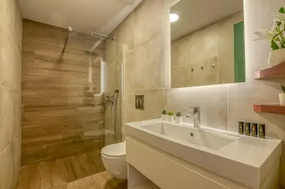 a bathroom with a sink and a toilet at Kaliviani Traditional Hotel in Kissamos