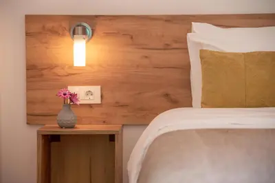 a bedroom with a bed and a vase with flowers on a table at Kaliviani Traditional Hotel in Kissamos