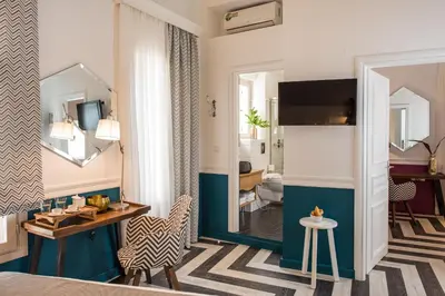 a hotel room with a bed and a table and a mirror at Elia Portou Due in Chania Town