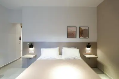 a bedroom with a large white bed with two night stands at Arocaria Apartments in Chania Town