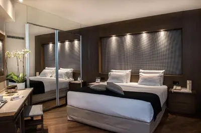 a hotel room with two beds and a desk at Civitel Akali Hotel in Chania Town