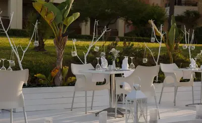 a group of tables and chairs with vases on them at Giannoulis - Santa Marina Plaza (Adults Only) in Agia Marina Nea Kydonias