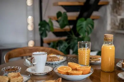a table topped with plates of food and orange juice at San Salvatore Monastery in Chania Town