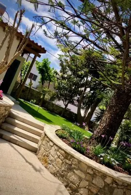 a house with a stone wall and a tree and stairs at Chorio House Platanias in Vrísai