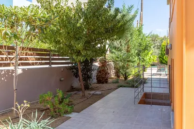 a walkway with trees and plants next to a building at Rea's Sea House in Kato Galatas