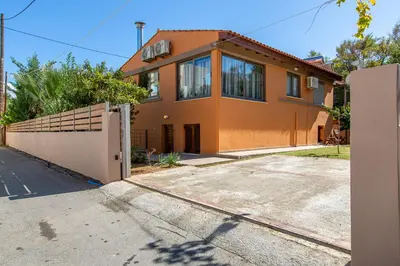 an orange house with a fence and a driveway at Rea's Sea House in Kato Galatas