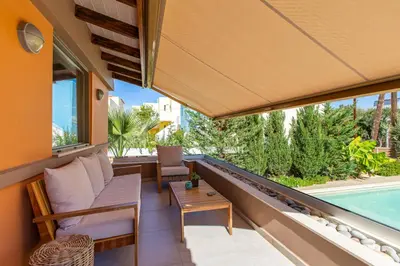 a balcony with a couch and a table and a pool at Rea's Sea House in Kato Galatas