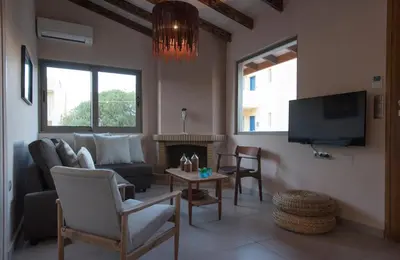 a living room with a couch and a tv at Rea's Sea House in Kato Galatas