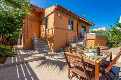 a patio with a table and chairs in front of a house at Rea's Sea House in Kato Galatas