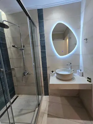 a bathroom with a sink and a mirror at Faros Rooms in Loutro