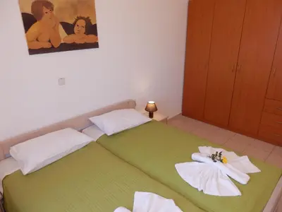 a bedroom with a green bed with towels on it at Maro Suites in Tavronitis