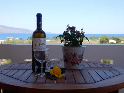 a bottle of wine and a glass on a table at Maro Suites in Tavronitis