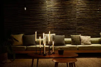 a living room with a couch with candles on a table at Domes Noruz Chania, Autograph Collection- Adults Only in Kato Daratso