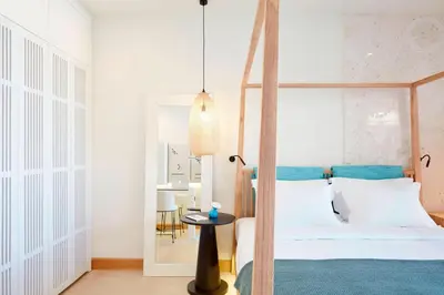 a bedroom with a canopy bed and a table at Domes Noruz Chania, Autograph Collection- Adults Only in Kato Daratso