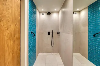 a bathroom with a shower with blue tiles at Domes Noruz Chania, Autograph Collection- Adults Only in Kato Daratso