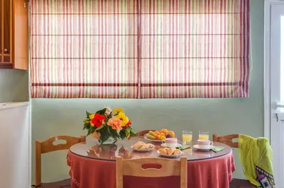 a table with a vase of flowers and fruit on it at Agapi Studios in Kato Daratso